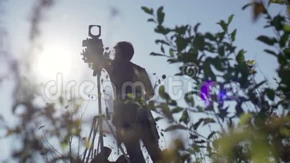 在绿树丛中男人会用复古相机视频的预览图