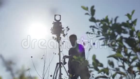 男人在绿树丛中设置复古相机视频的预览图