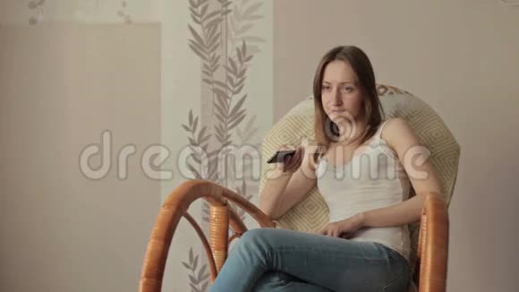 扶手椅上的女孩带遥控器的摇杆视频的预览图