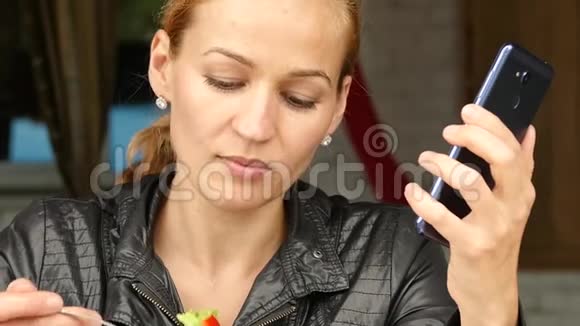 在户外咖啡馆吃午饭女商人吃沙拉检查你手机上的电子邮件慢动作视频的预览图