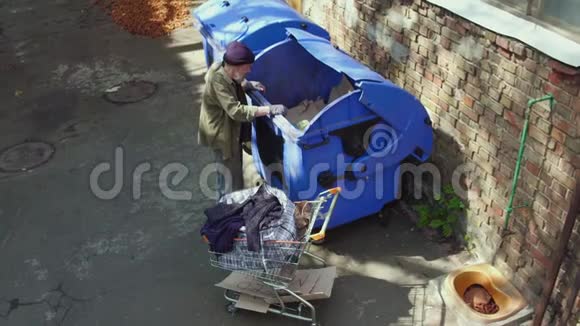 无家可归的人在垃圾桶里找食物视频的预览图