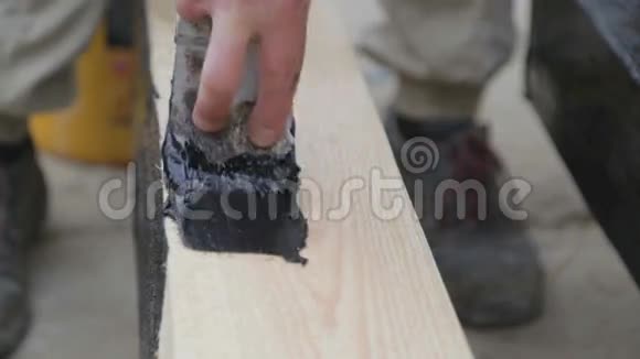 在木梁上涂抹液体沥青视频的预览图