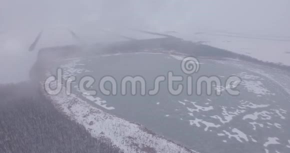 镜头在雾中飞过湖面和白雪覆盖的森林4K视频的预览图