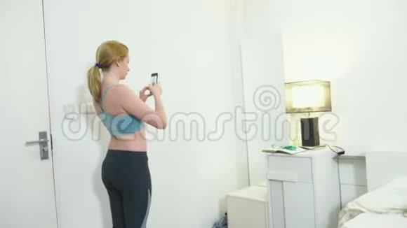 超重和减肥的概念一个女人看着镜子里的自己给她的身材拍照比较视频的预览图