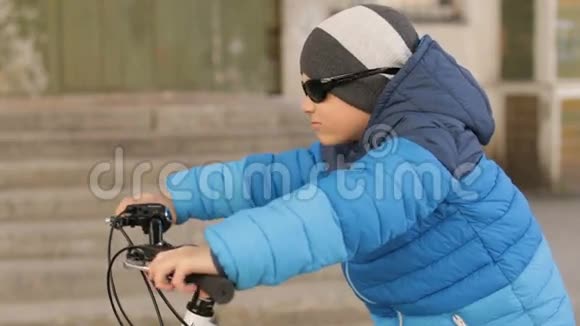 一个戴太阳镜的男孩坐在自行车上全高清视频视频的预览图