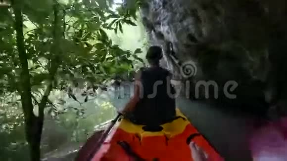 在红树林的峡谷中老人划着皮艇视频的预览图