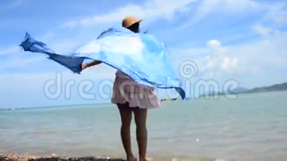 泰国妇女在海滩上放松和玩靛蓝领带染料织物披肩视频的预览图