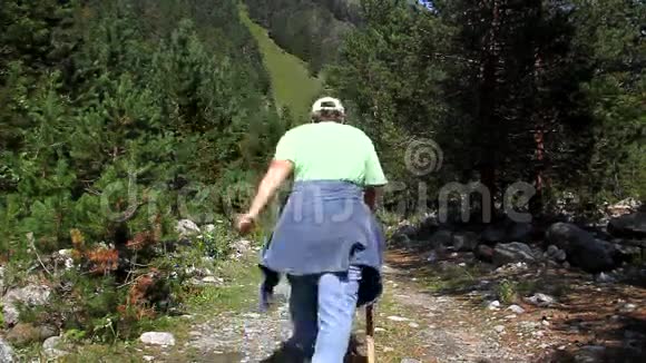 一位手持拐杖的老年妇女走在岩石路上视频的预览图