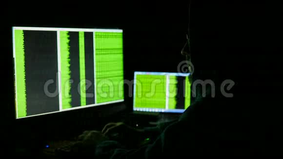 电脑显示器后面的人网络成瘾反映黑客犯罪眼镜浏览深夜代码网络视频的预览图