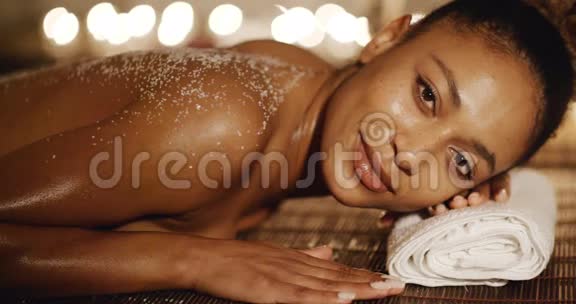 女人躺在按摩台上用盐擦视频的预览图