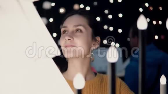 年轻迷人的黑发女孩在商店选择灯具圣诞节装饰视频的预览图