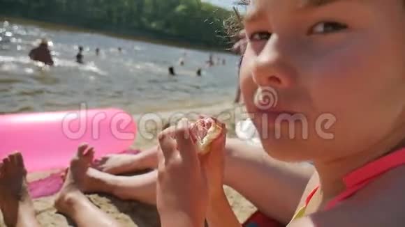 少女在海滩度假慢动作视频中吃三明治视频的预览图