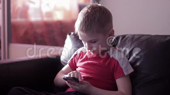 在家玩智能手机的小男孩视频的预览图