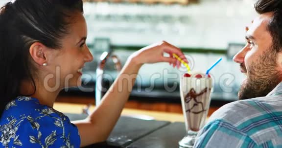 快乐的一对夫妇在吃奶昔的时候互动视频的预览图