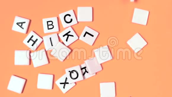 塑料字母在橙色表面弹起并显示字母视频的预览图