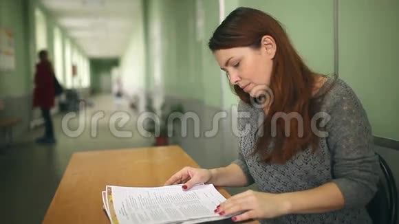 女老师检查坐在桌子上的作业视频的预览图