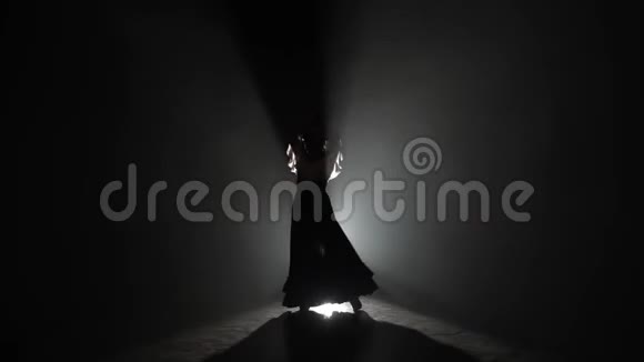 弗拉门戈女孩手里拿着石膏跳舞从后面的光烟雾背景视频的预览图