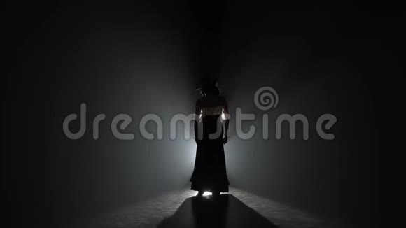 女孩手里拿着石膏跳舞从后面的光烟雾背景视频的预览图