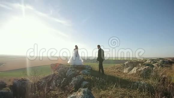 喜结连理的新婚夫妇新郎新娘在户外的山上举行婚礼视频的预览图