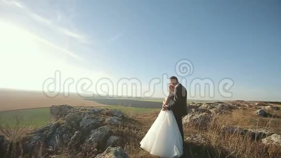 喜结连理的新婚夫妇新郎新娘在户外的山上举行婚礼视频的预览图