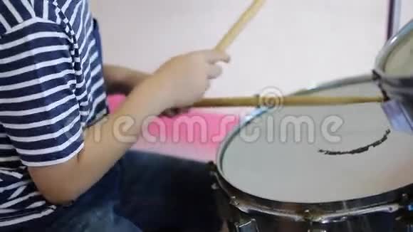 亚洲儿童鼓手练习表演的特写镜头视频的预览图