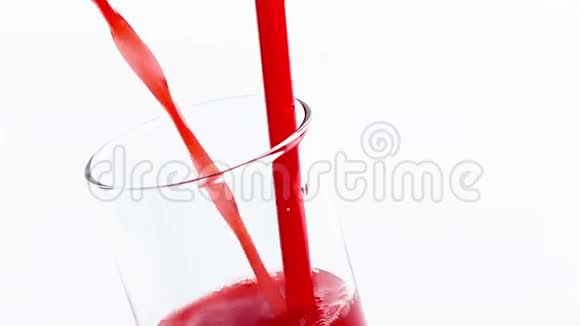 将红色橙汁倒入白色背景下的玻璃杯中视频的预览图