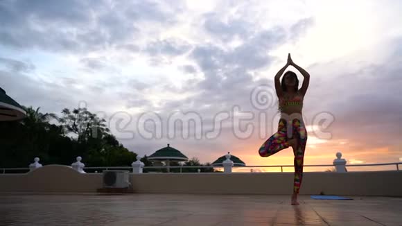 日落时练习瑜伽的女孩视频的预览图