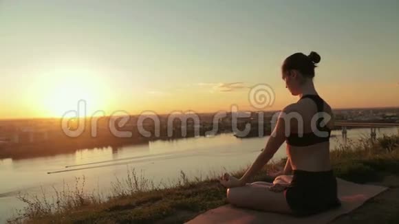 日落时分在公园里莲花位置的运动女人视频的预览图