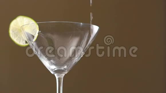 在杯中加入龙舌兰酒背景上有一片石灰慢慢地视频的预览图