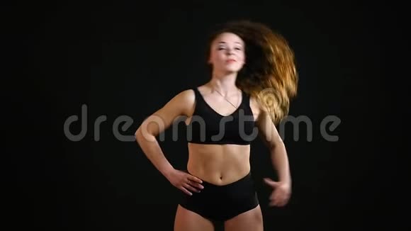 运动女孩在黑色背景下锻炼视频的预览图