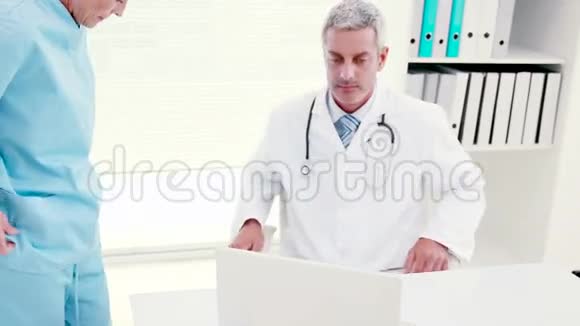 专心的医生看着笔记本电脑视频的预览图