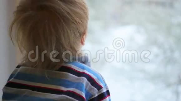 一个孩子望着窗外的降雪视频的预览图