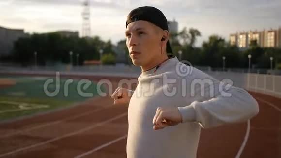 运动前做热身运动和慢跑的年轻运动员视频的预览图
