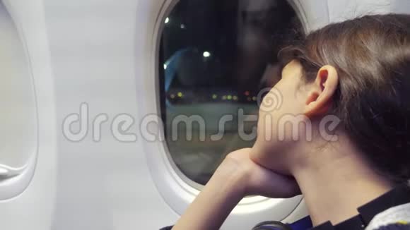 少女航空飞机概念年轻女孩看着坐在窗边的飞机生活方式夜间飞行视频的预览图