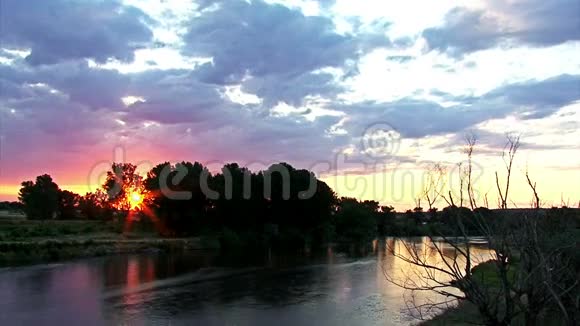 日落时间随着移动的云在河流和森林中流逝视频的预览图