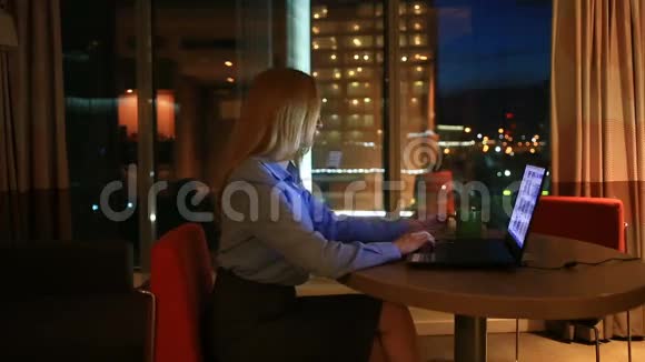 漂亮的金发商务女性在执行办公室加班城市灯光在背景中可见视频的预览图