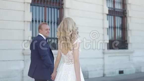 一对夫妇走在大皇宫附近优雅的新郎和新娘穿着婚纱爱情视频的预览图