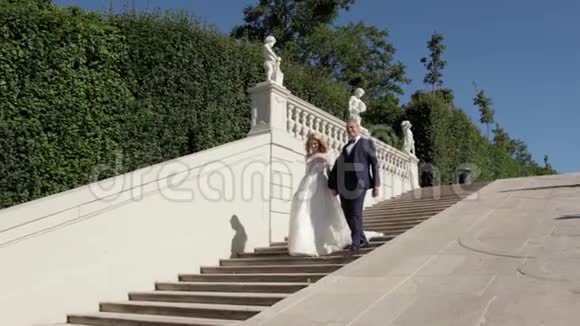 一对夫妇走在大皇宫附近优雅的新郎和新娘穿着婚纱爱情视频的预览图
