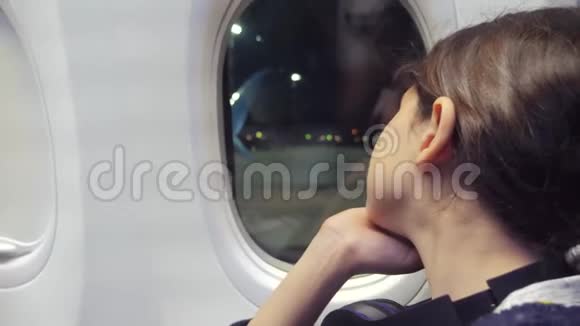 少女航空飞机概念年轻女孩看着坐在窗边的飞机夜间生活方式飞行视频的预览图