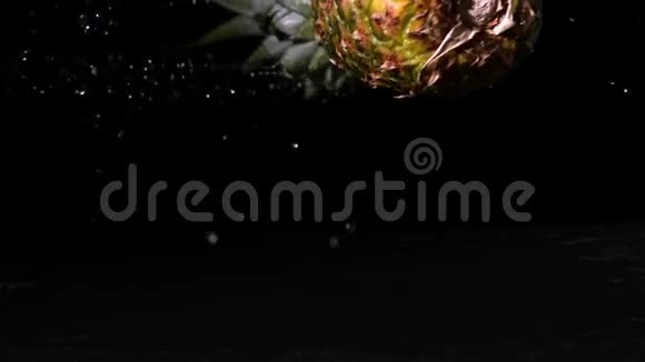 菠萝在潮湿的黑色表面上旋转视频的预览图