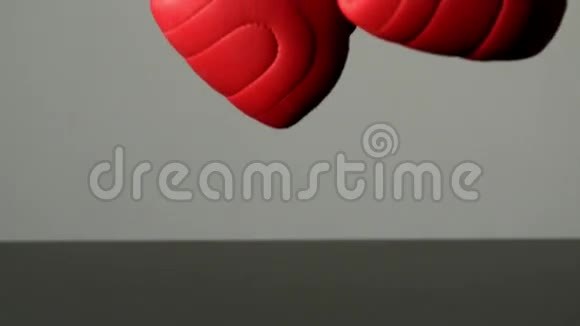 红色拳击手套掉落在黑色表面视频的预览图