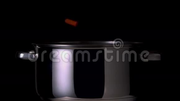 黑色背景下落入锅中的蔬菜视频的预览图