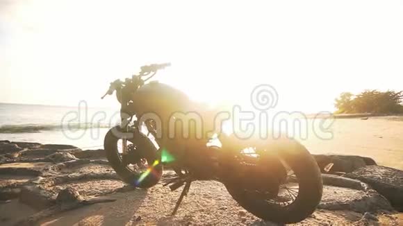 日落时骑摩托车在海滩上视频的预览图