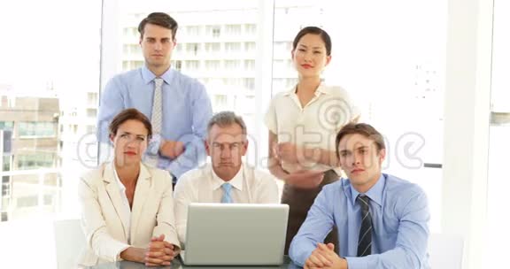 严肃的商业团队在笔记本电脑前摆姿势视频的预览图