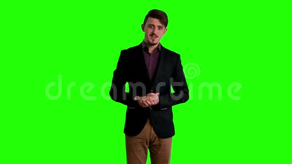 穿着夹克的人站在绿色屏幕的背景下视频的预览图