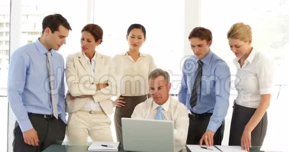 商务团队在笔记本电脑前然后指向相机视频的预览图