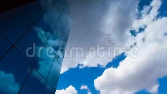 仰望一座玻璃覆盖的摩天大楼映着蓝天和白云视频的预览图
