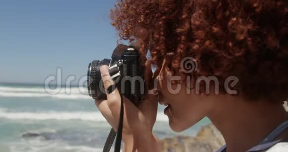 在海滩上用数码相机拍照的女人视频的预览图