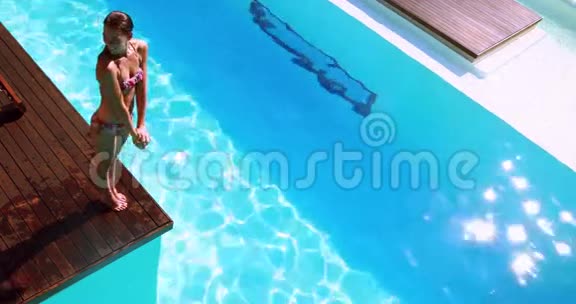 布鲁内特潜入清澈的蓝色游泳池视频的预览图