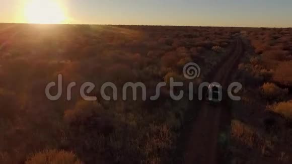 日落时观赏纳米比亚的热带草原还有一辆旅行车视频的预览图
